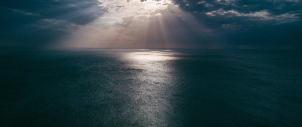 Sunbeams over a dark ocean